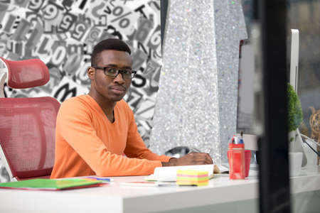 Young Black Man in the office behind his deskの写真素材