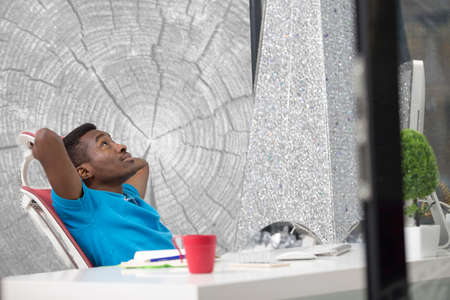 Furious black businessman tired of working on project at office.