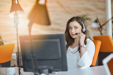 Attractive woman listening to music while working in startup business officeの写真素材