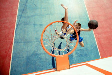 High angle view of basketball player dunking basketball in hoop
