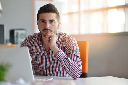 Man in modern office start-up working on laptop.