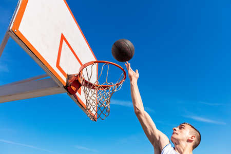 Slam Dunk. Side view of young basketball player making slam dunk