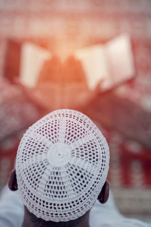Top viewv of African Muslim Man Making Traditional Prayer To God While Wearing A Traditional Cap Dishdashaの写真素材