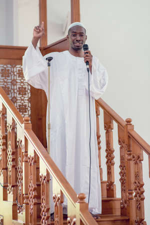 Muslims black african Imam has a speech on friday afternoon prayer in a mosque