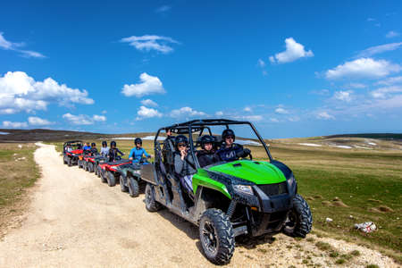 Friends driving off-road with quad bike or ATV and UTV vehicles