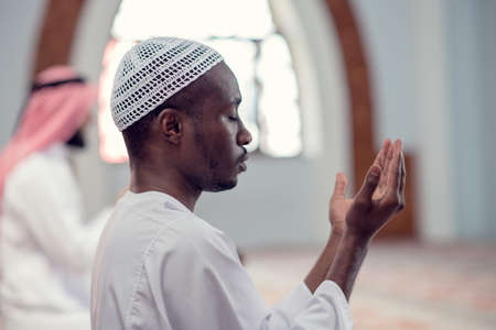 Two religious muslim man praying together inside the mosqueの写真素材