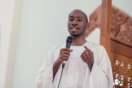 Muslims black african Imam has a speech on friday afternoon prayer in a mosque