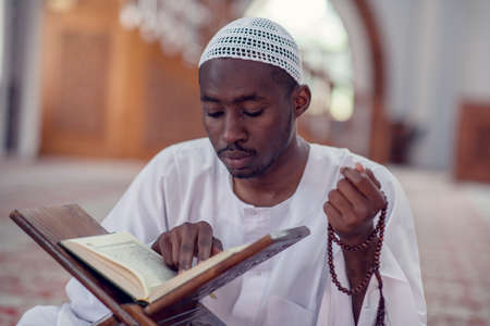 African Muslim Man Making Traditional Prayer To God While Wearing Dishdashaの写真素材