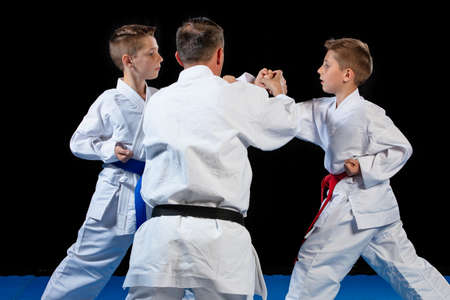 Male karate instructor training little children in dojoの写真素材