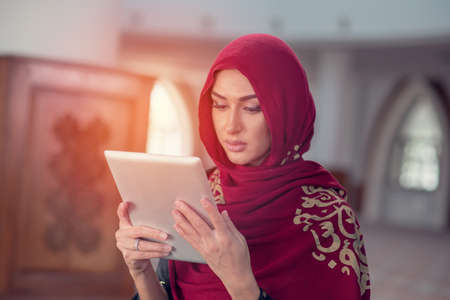 Beautiful young woman with tablet computer inside mosqueの写真素材