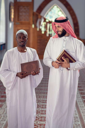 Two religious muslim man walking together inside the mosqueの写真素材