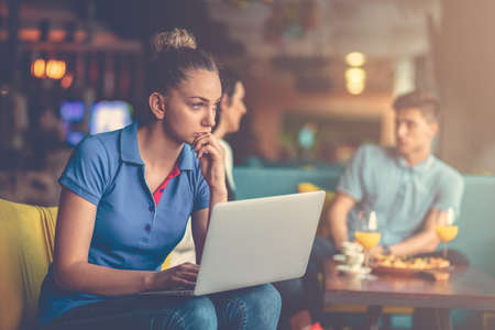 Young female student is using laptop computer in cafeの写真素材