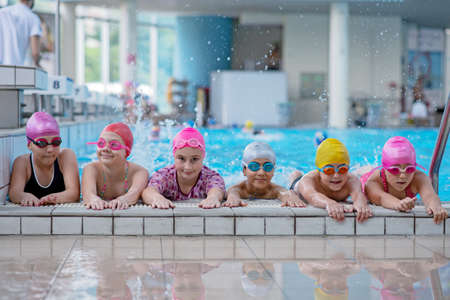 happy kids at the swimming pool. young and successful swimmers pose.