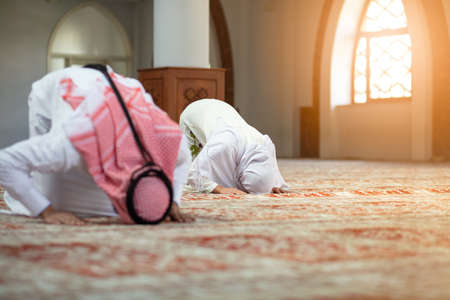Muslim man and woman praying in mosqueの写真素材