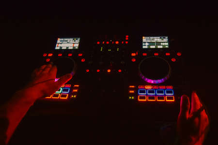 Dj mixes the track in the nightclub at party. DJ hands in motionの写真素材