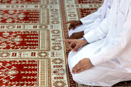 Two religious muslim man praying together inside the mosqueの写真素材