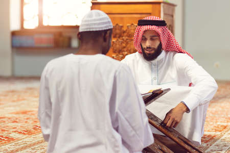 Two religious muslim man praying together inside the mosqueの写真素材