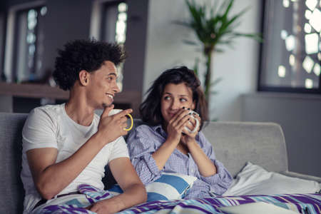 Young couple watching a movie on their laptop in bed