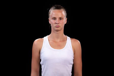 Portrait of beautiful woman playing tennis indoor. Isolated on black.