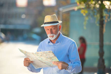 Happy smiling elder man tourist ready for journey, looking for direction.の写真素材
