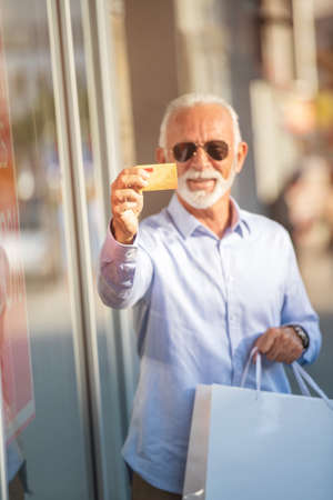 technology, people, lifestyle and communication concept - senior man texting message on smartphone in cityの写真素材