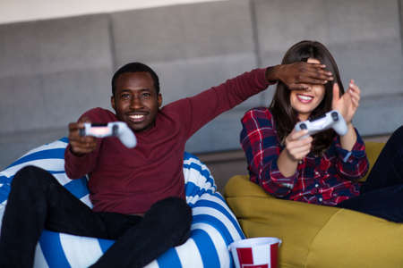 Young Couple at home Playing Video Game Togetherの写真素材