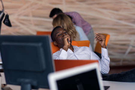 Happy smiling successful African American businessman in in a modern bright startup office indoors