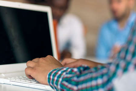 hands with laptop typing with people in backgroundの写真素材