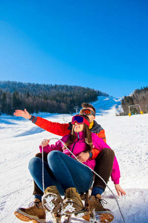 Young Happy Couple On Sledge Having Funの写真素材