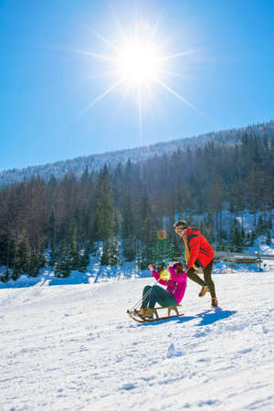Young Happy Couple On Sledge Having Funの写真素材