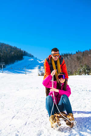 Young Happy Couple On Sledge Having Funの写真素材