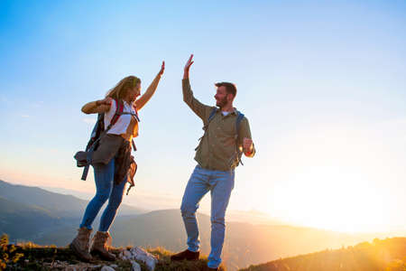 Couple on Top of a Mountain Shaking Raised Handsの写真素材