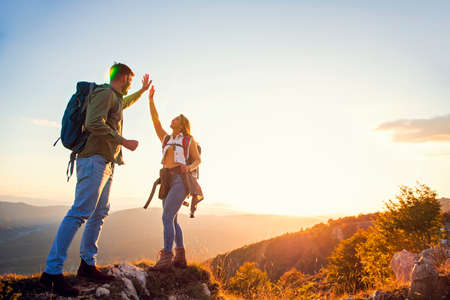 Couple on Top of a Mountain Shaking Raised Hands.の写真素材