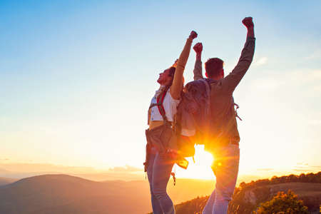 Couple on Top of a Mountain Shaking Raised Hands.の写真素材