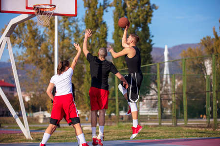 Group Of Young Friends Playing Basketball Matchの写真素材