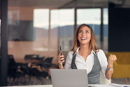 Modern business woman in the office working at computerの写真素材