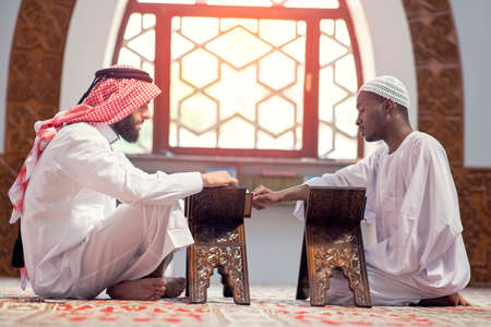 Two religious muslim man praying together inside the mosqueの写真素材