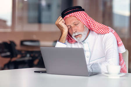 Arab businessman is boring in modern office. Tired.の写真素材