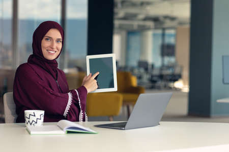 professional young muslim business woman using mobile digital tablet computer at workの写真素材