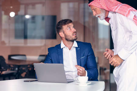 Mature Middle Eastern businessman wearing ghoutra in meetingの写真素材