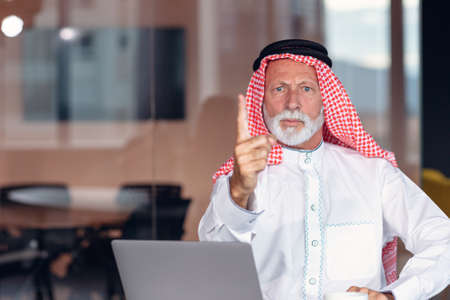 Arab businessman points a warning finger at the camera.の写真素材