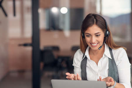 Modern business woman in the office working at computerの写真素材