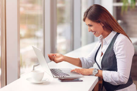 Modern business woman in the office working at computerの写真素材