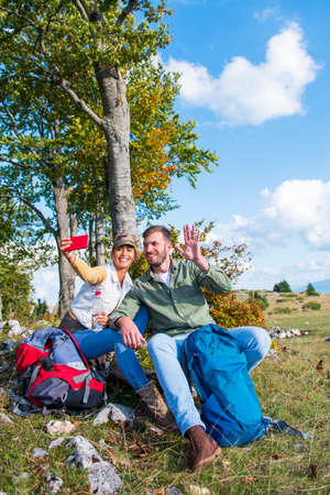 Cheerful young couple taking a selfie outdoor during the travel in the mountainsの写真素材