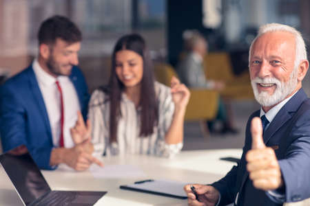 Positive aged couple consulting with insurance agentの写真素材