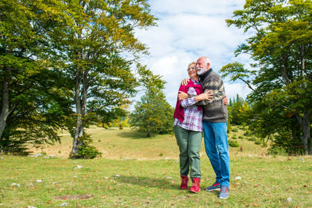 Senior couple on a walk in an autumn nature.の写真素材