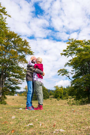 Elderly couple embracing in autumn park. Enjoying in love.の写真素材