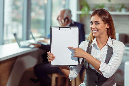 Business woman hold white blank paper. Young smiling.の写真素材