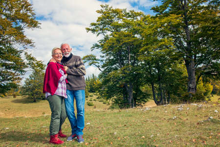 Senior couple on a walk in an autumn nature.の写真素材