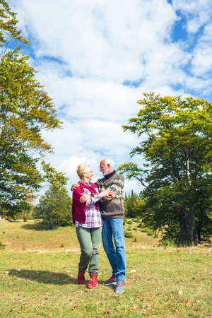 Senior couple on a walk in an autumn nature.の写真素材